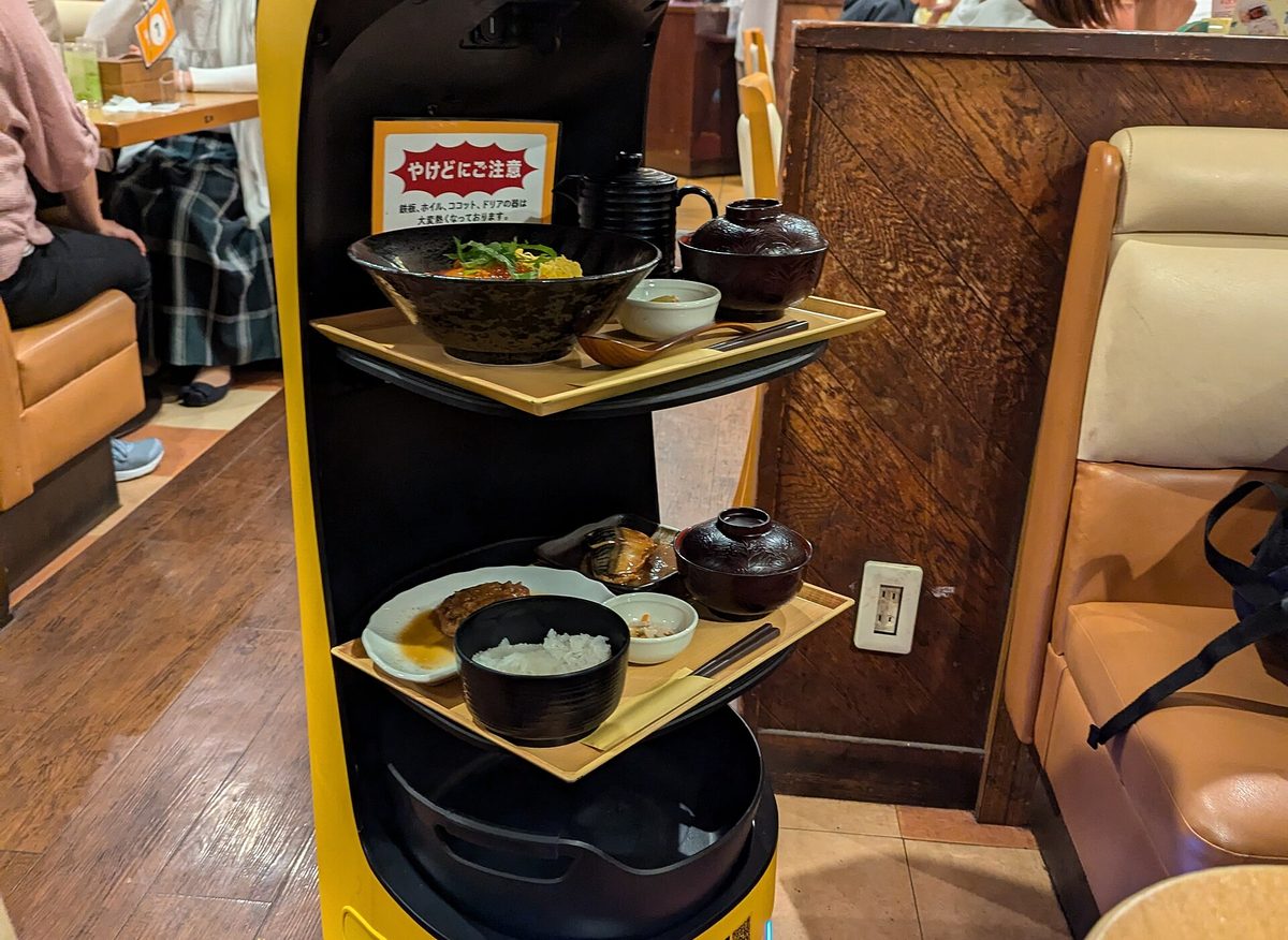 A serving robot carrying dishes between booths at a family restaurant in Japan
