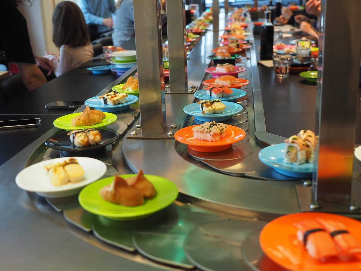 Plates of sushi in different colors moving along a conveyor belt