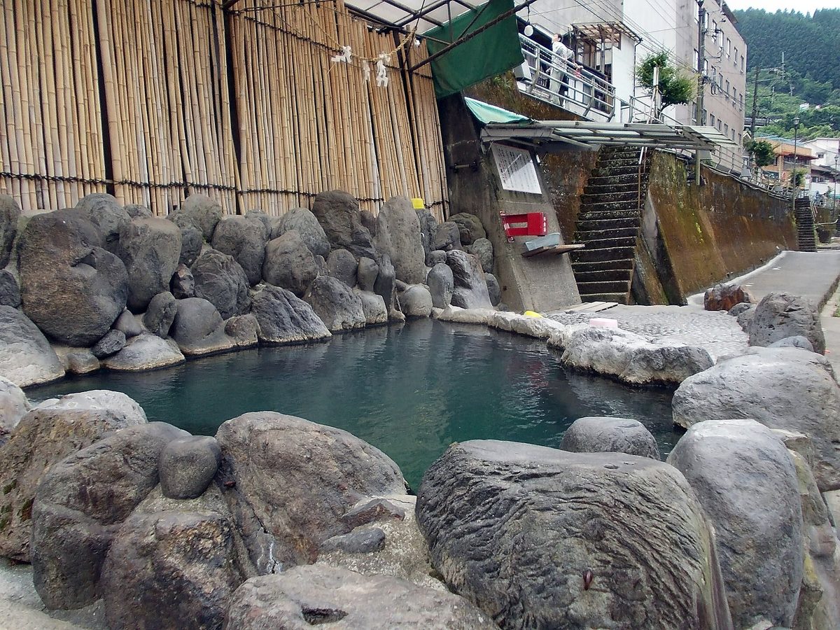 An empty open-air rock bath beside a river