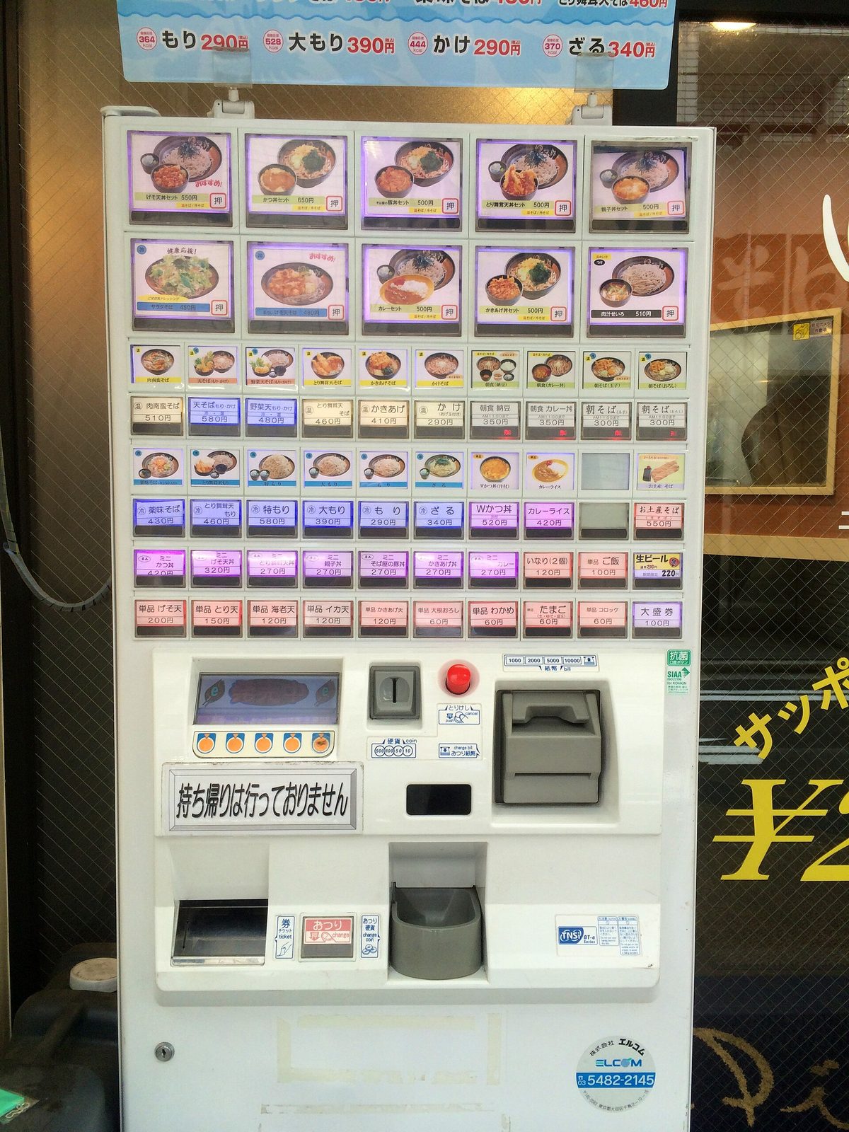 A meal ticket vending machine with rows of buttons showing dishes