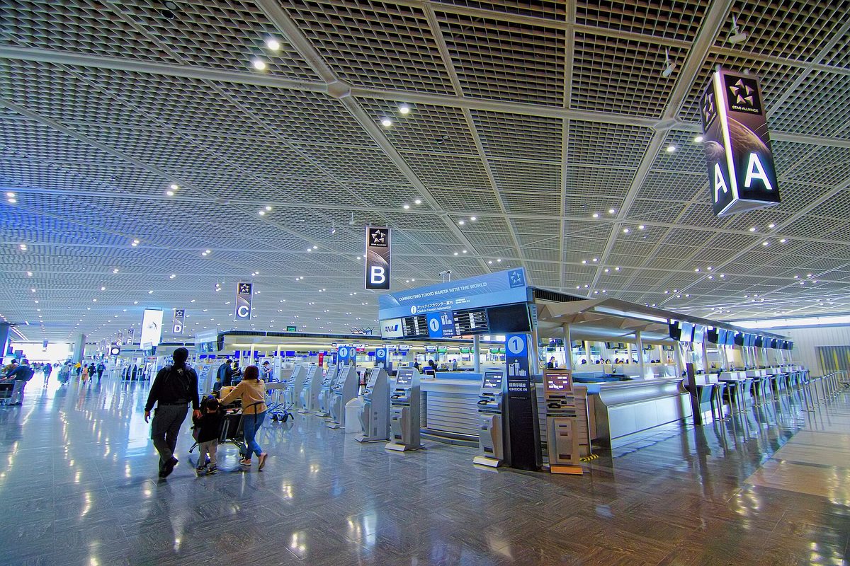 The wide departure lobby of Narita Airport with check-in machines